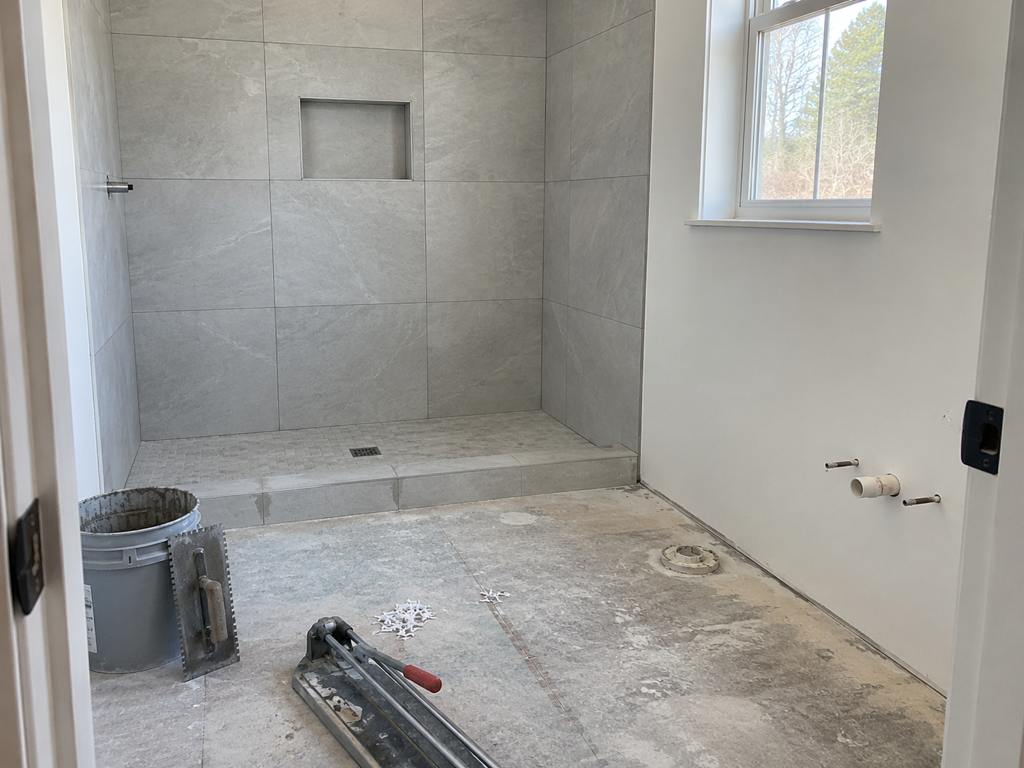 Example bathroom with finished shower wall tile and unfinished floor area